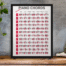 framed-art-print-standing-on-a-wooden-desk-against-a-concrete-wall-near-a-hand-decoration-a10403